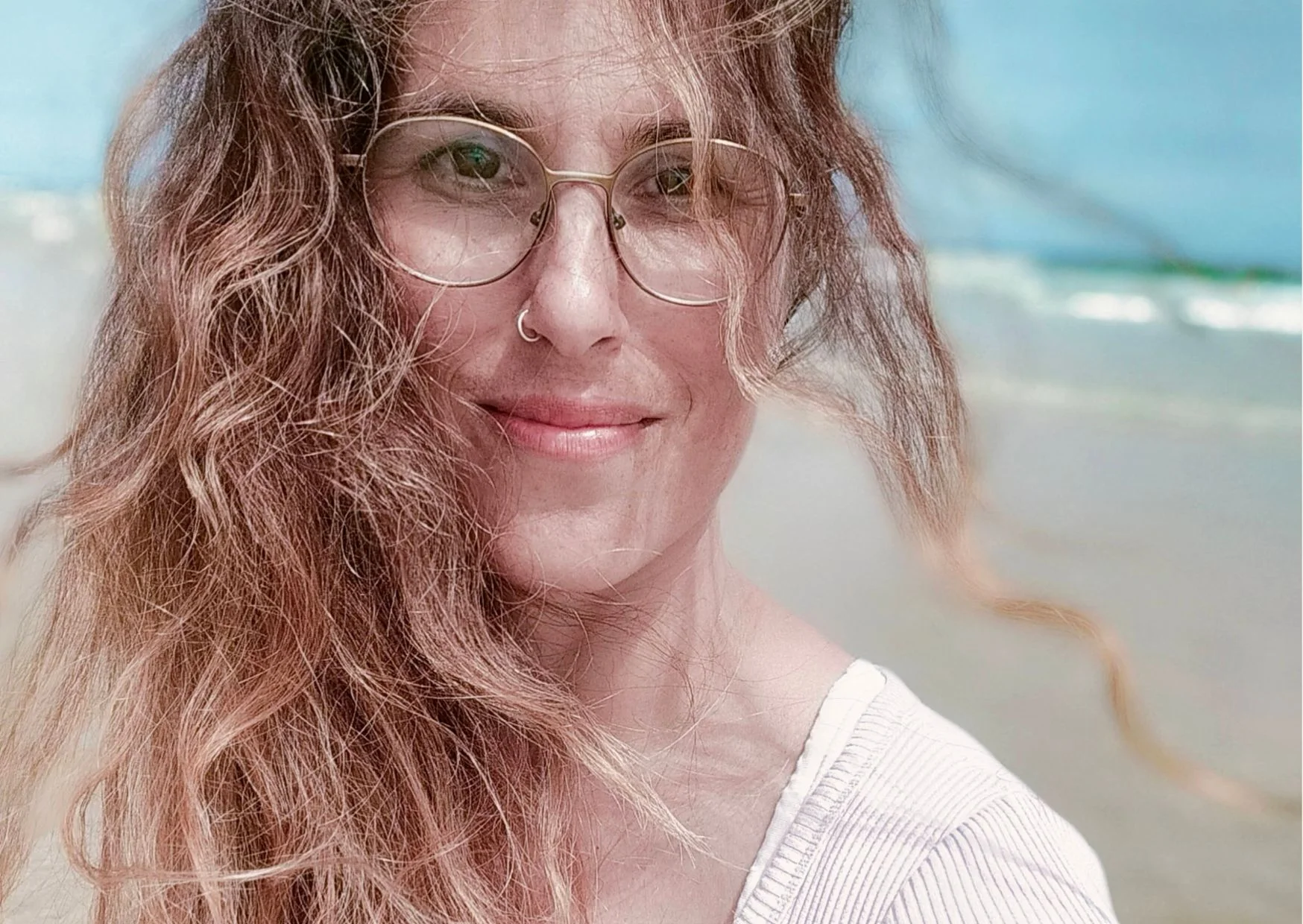 Portrait Zerrin Kaya, wildes gelocktes Haar, Brille, nasenpircing, sanft, lächeln