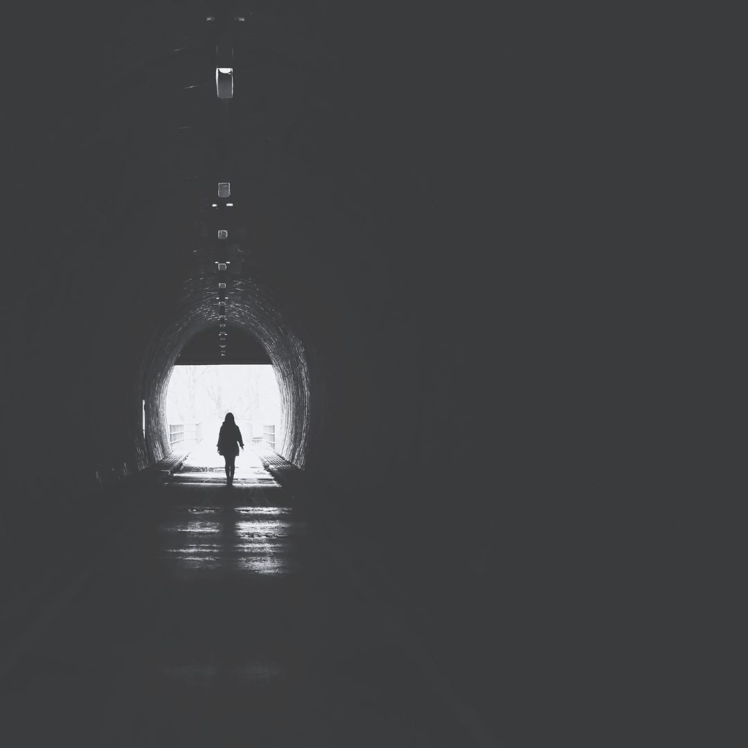 Ein Mensch in einem dunkeln Tunnel der Zweifel